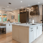 luxury kitchen with double island with natural stone countertops, bespoke pendant lighting