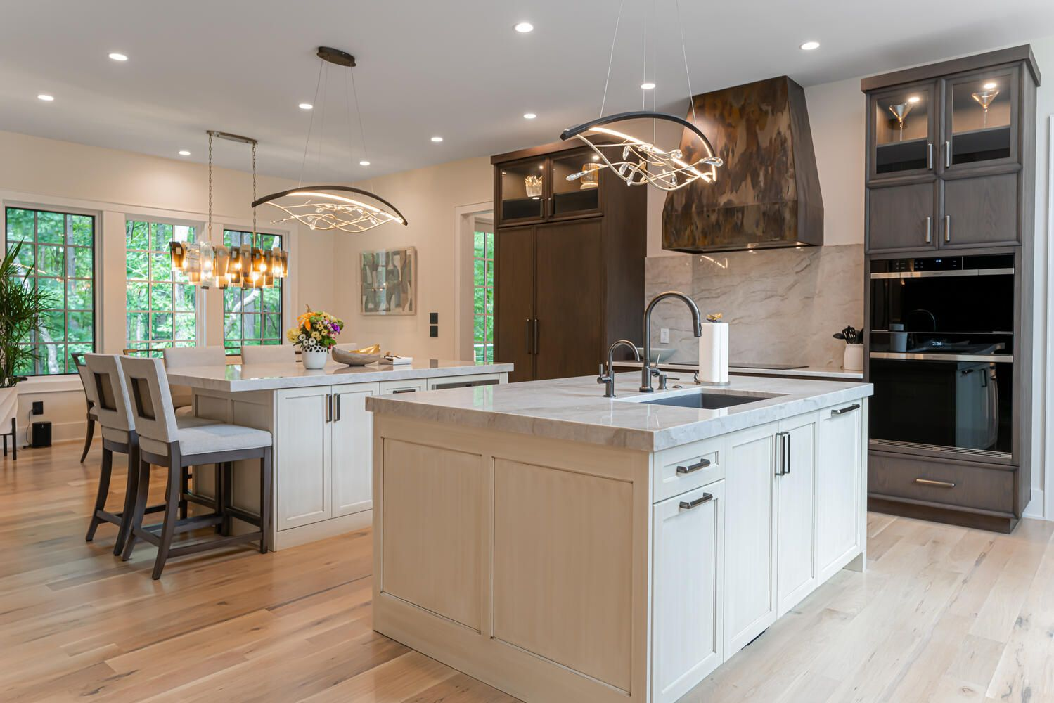 luxury kitchen with double island with natural stone countertops, bespoke pendant lighting